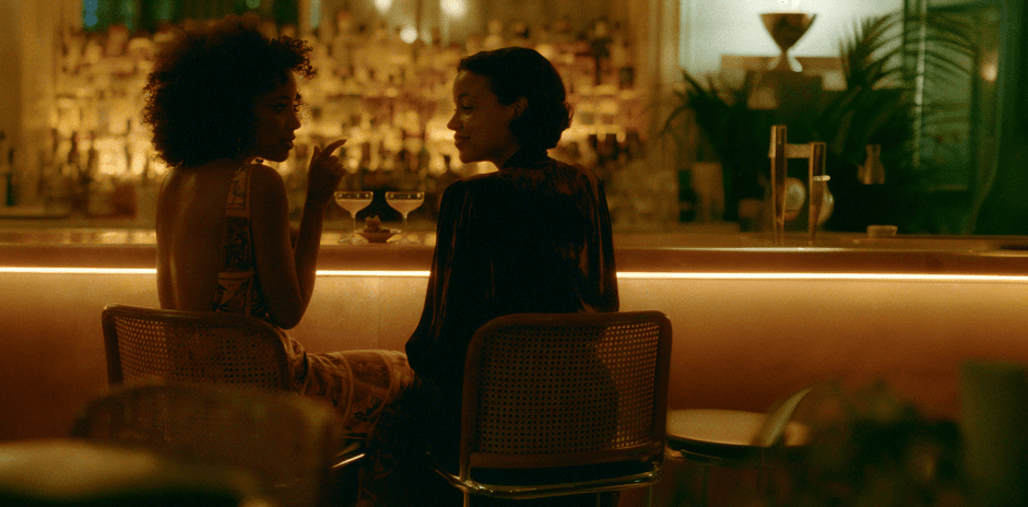 Two members talking over cocktails at a club bar