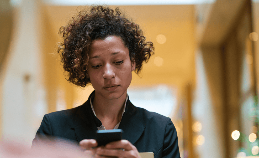 A member checking her phone in a club lobby