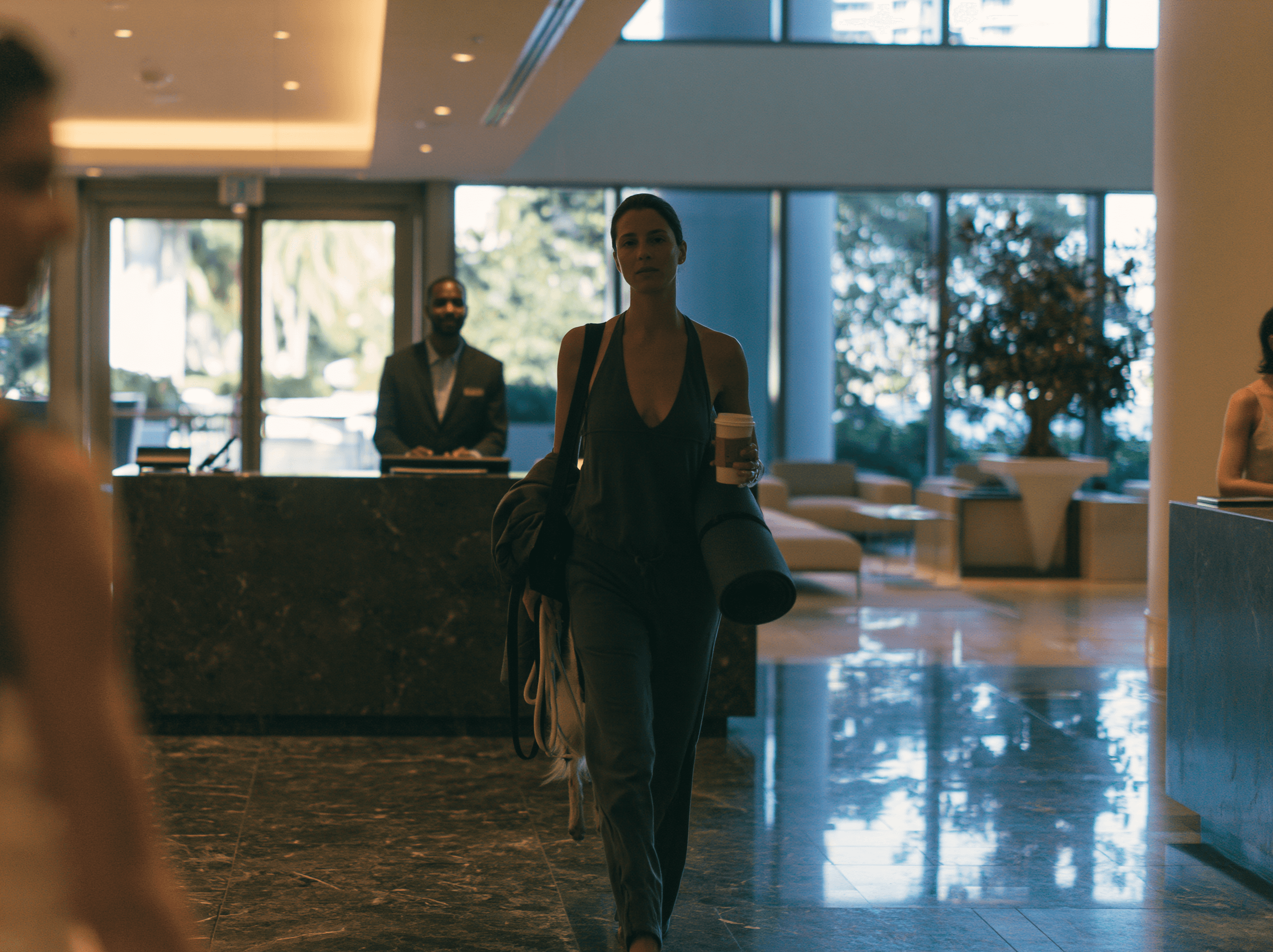 A resident walking past the concierge desk in a bright lobby
