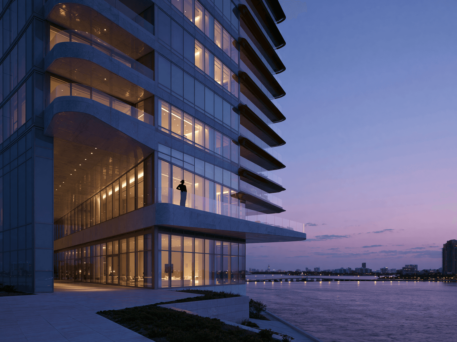 Modern waterfront hotel tower glowing at dusk